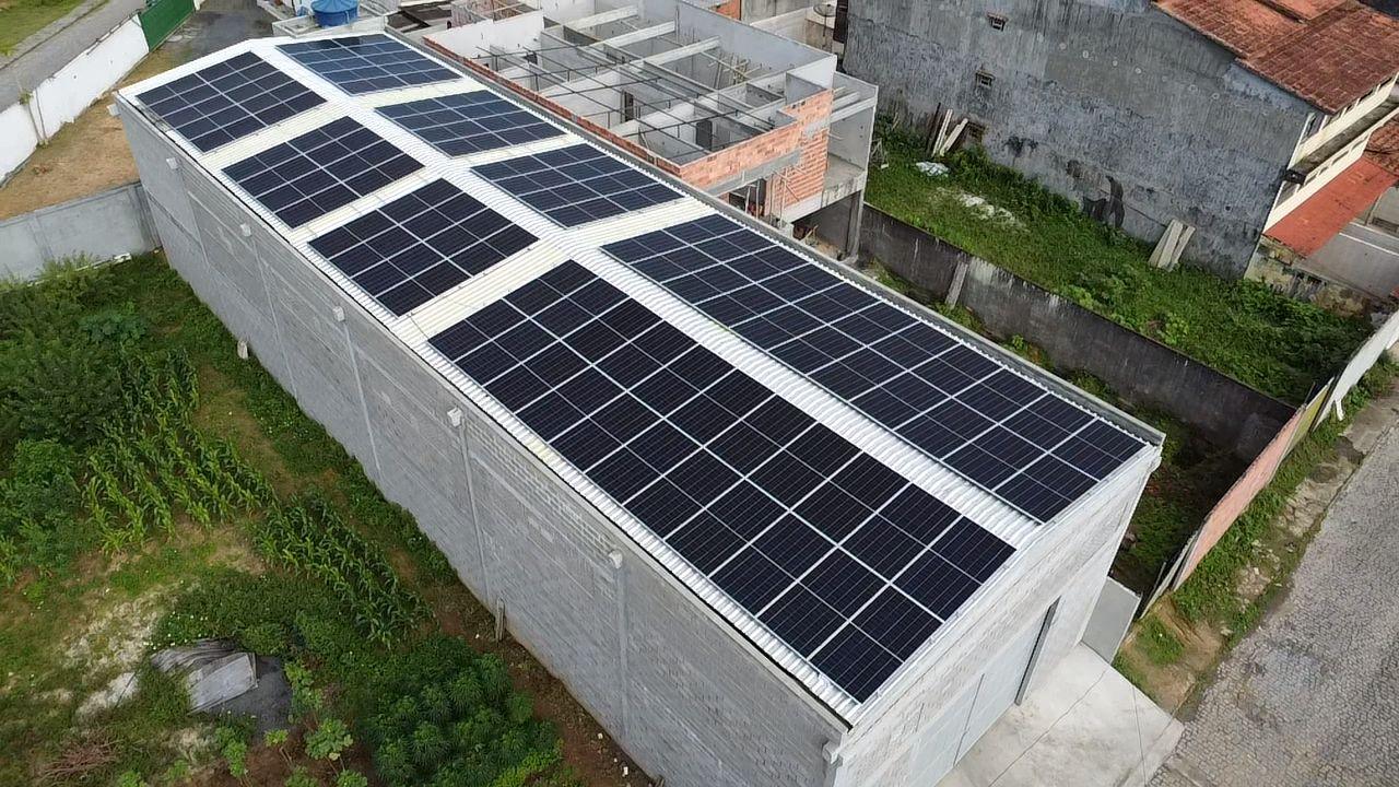 Painéis solares no telhado metálico de um galpão