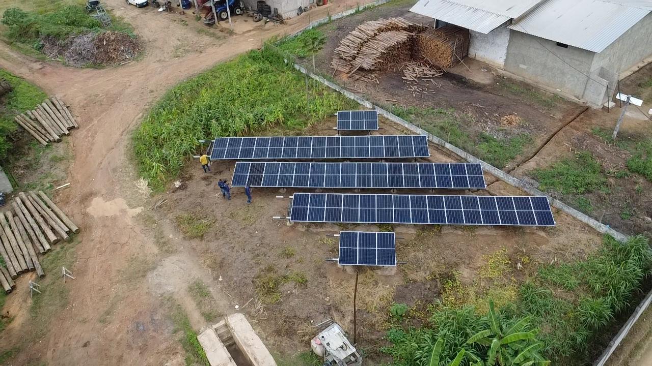 Equipe instalando usina solar em solo numa propriedade rural